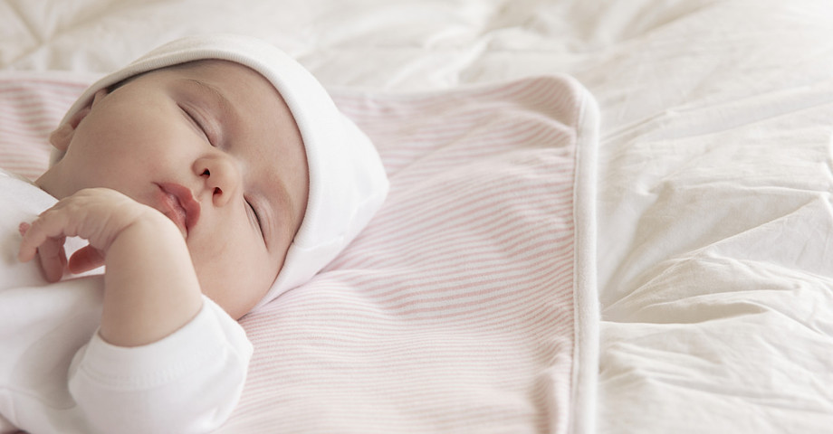 Ein friedlich schlafender Säugling, schlummerndes Neugeborenes, Baby.